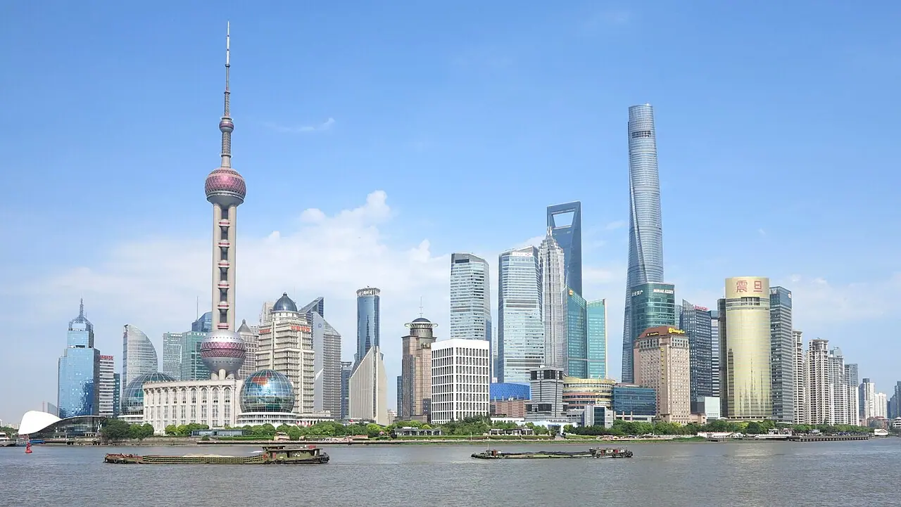Shanghai skyline from the Bund—Wikimedia Commons stock photograph of a major Chinese city; it illustrates urban scale and economy, not census counts, age structure, or any specific policy named in the article.