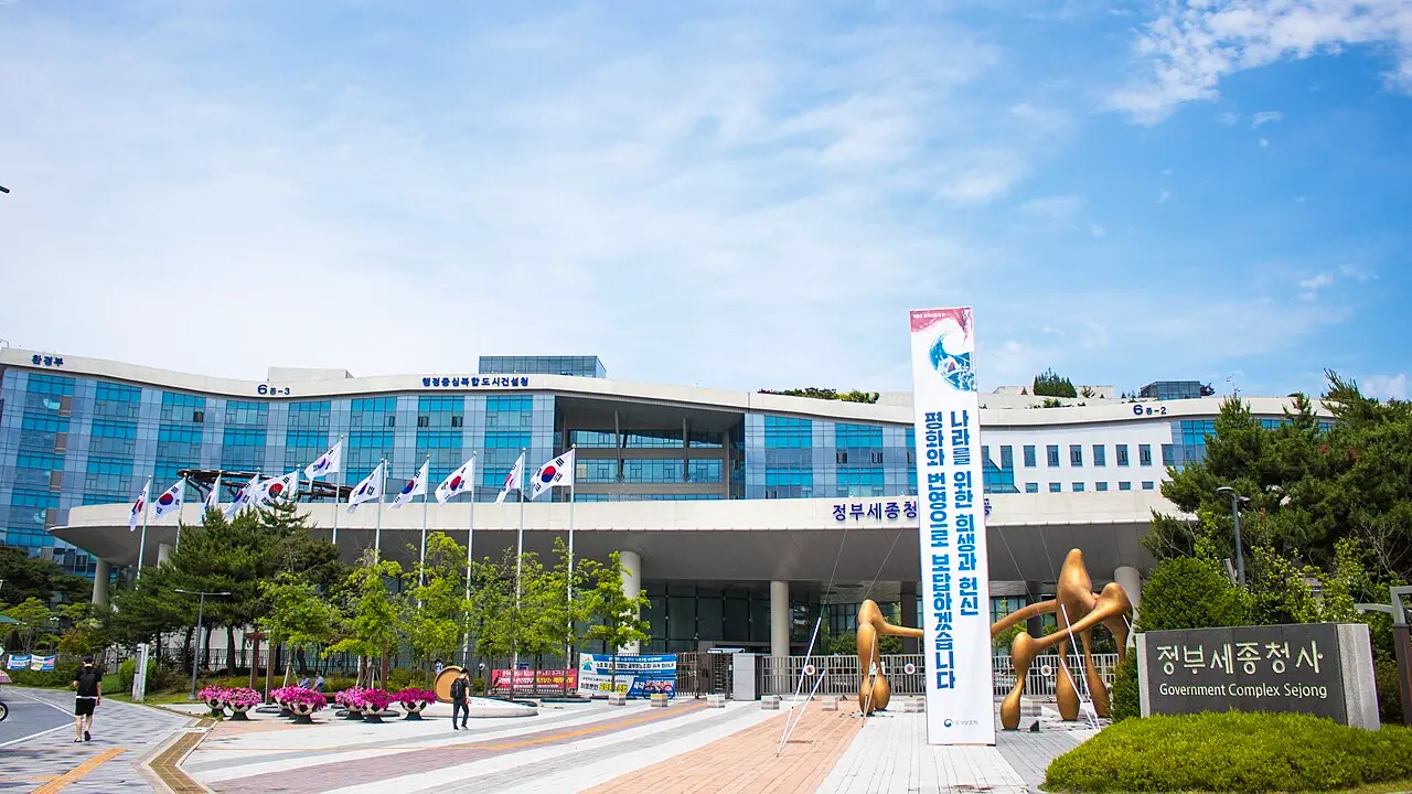 Government Complex Sejong main entrance, South Korea, June 2019 (Wikimedia Commons, CC BY-SA 3.0)—the administrative campus in Sejong where the National Labor Relations Commission hosts government-mediated talks referenced in the story; not a Samsung plant gate, union picket, or interior hearing room from May 2026.